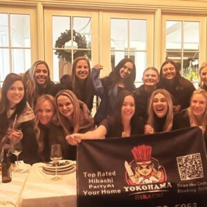Birthday party hibachi catering with guests holding a Yokohama Hibachi banner